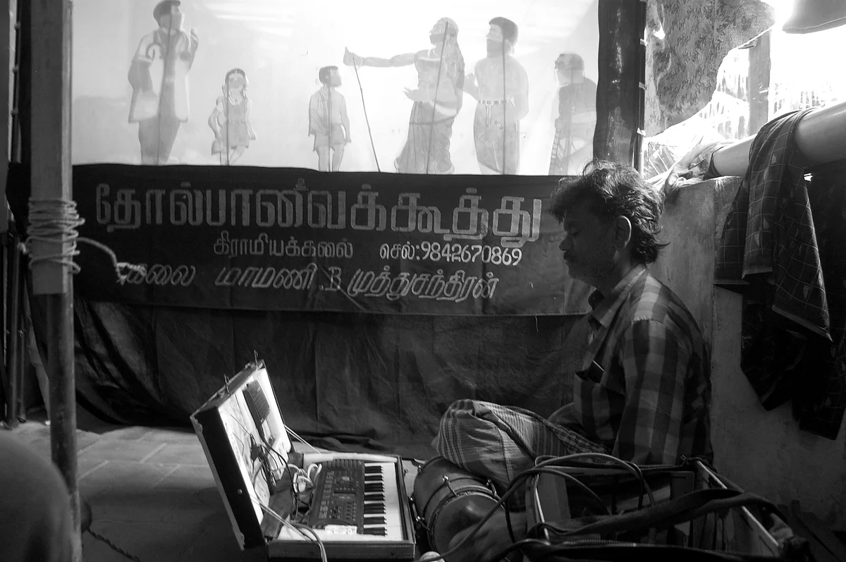 பொம்மைகளின் அசைவிற்கு ஏற்ப தாளம் இசைக்கும் கலைஞர்