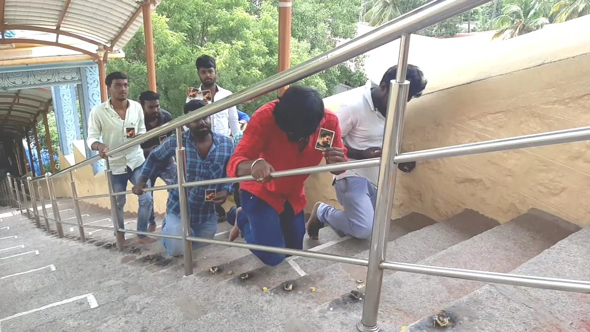 மண்டியிட்டு படிக்கட்டில் ஏறிய ரசிகர்கள்