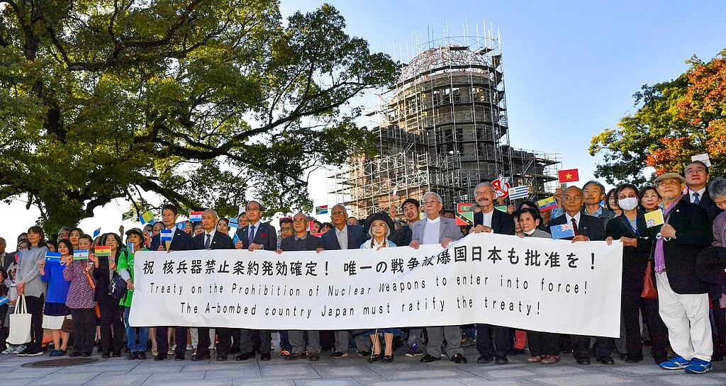 Members of Atomic Bomb survivors groups gather, holding a banner calling for Japanese government to ratify the Treaty on the Prohibition of Nuclear Weapons, with the Atomic Bomb Dome in background, in Hiroshima, western Japan