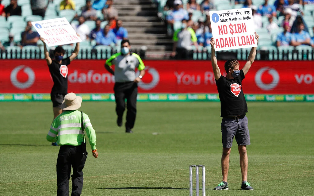 Protesters hold up banners as they interrupt the one day international cricket match between India and Australia at the Sydney Cricket Ground in Sydney, Australia