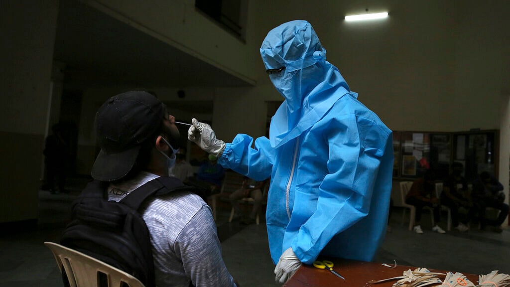 A health worker takes a nasal swab sample