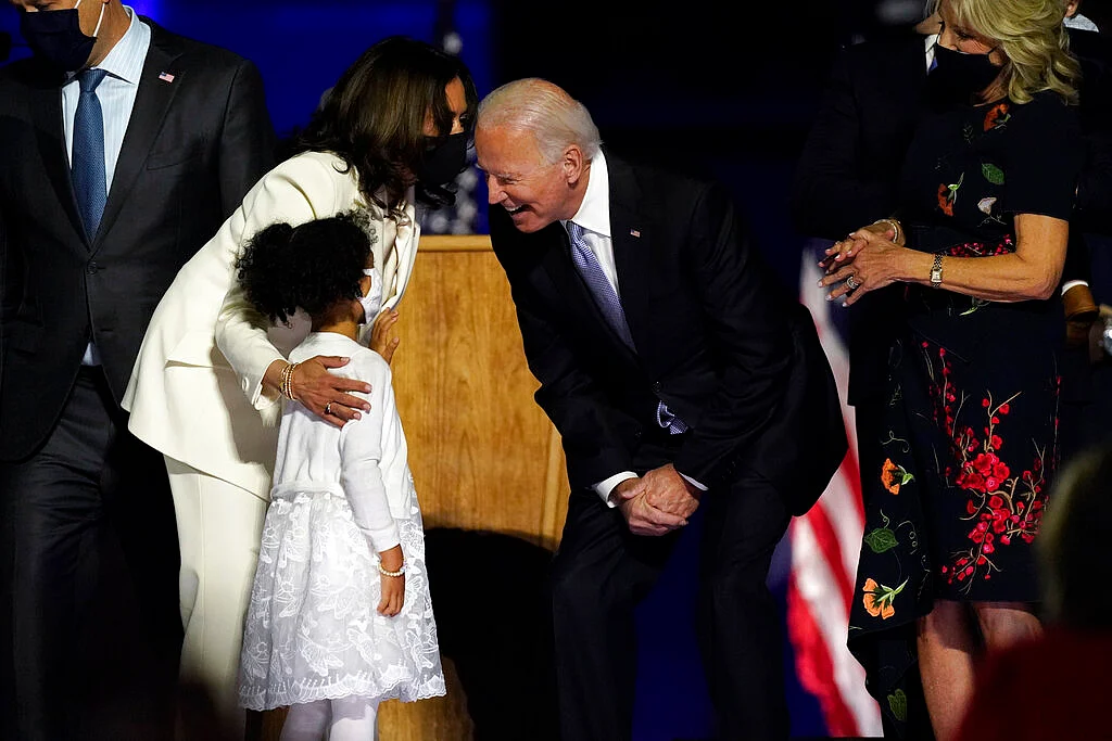 Vice President-elect Kamala Harris and President-elect Joe Biden stand on stage with family