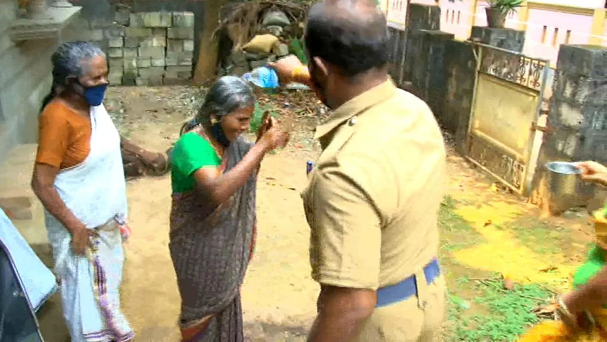 தீக்குளிக்க முயன்ற பெண்ணை மீட்கும் போலீஸ்