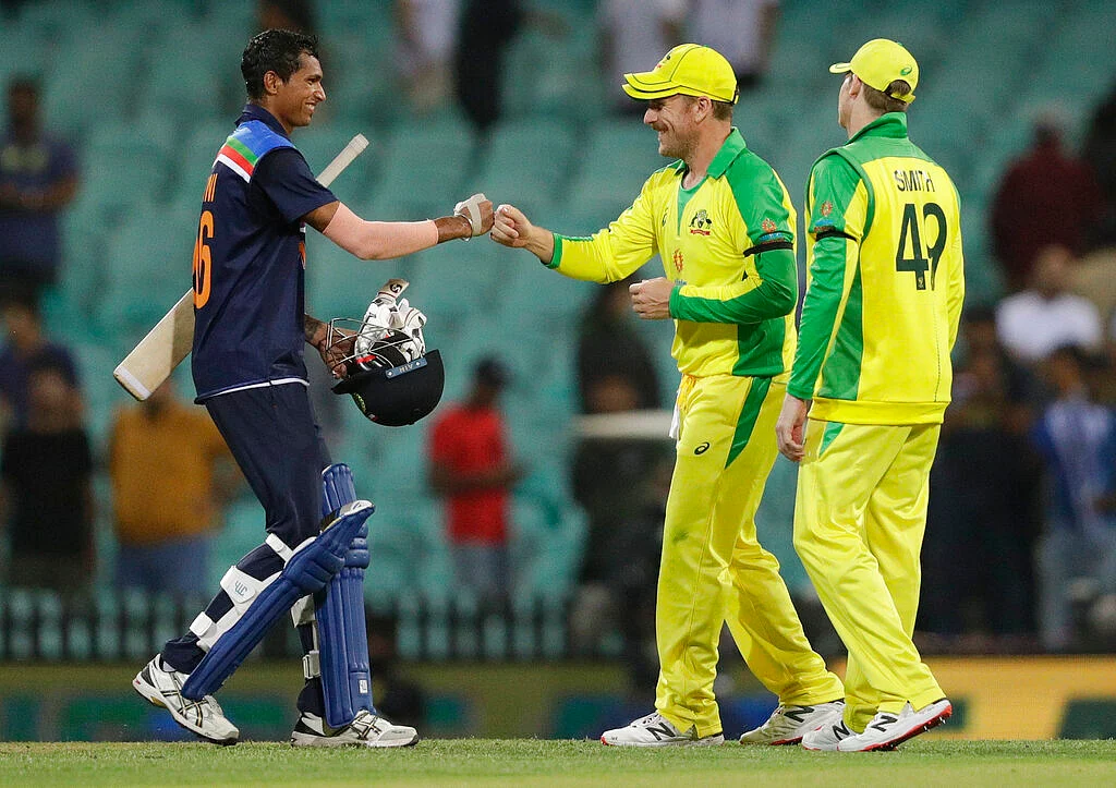 India's Navdeep Saini, left, gestures to Australia's Aaron Finch as Steve Smith watches following the one day international cricket match between India and Australia at the Sydney Cricket Ground in Sydney, Australia