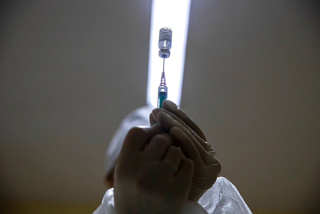A medical worker, right, prepares a shot of Russia's Sputnik V coronavirus vaccine in Moscow, Russia