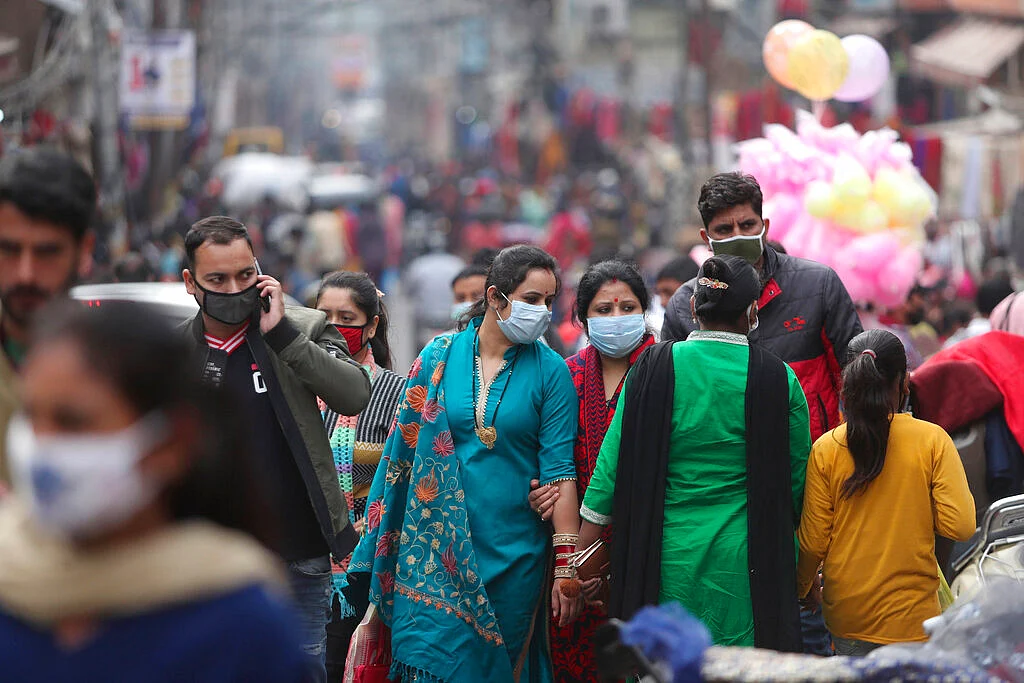 Indians, most of them, wearing face masks as a precautionary measure against the coronavirus crowd a Sunday market in Jammu