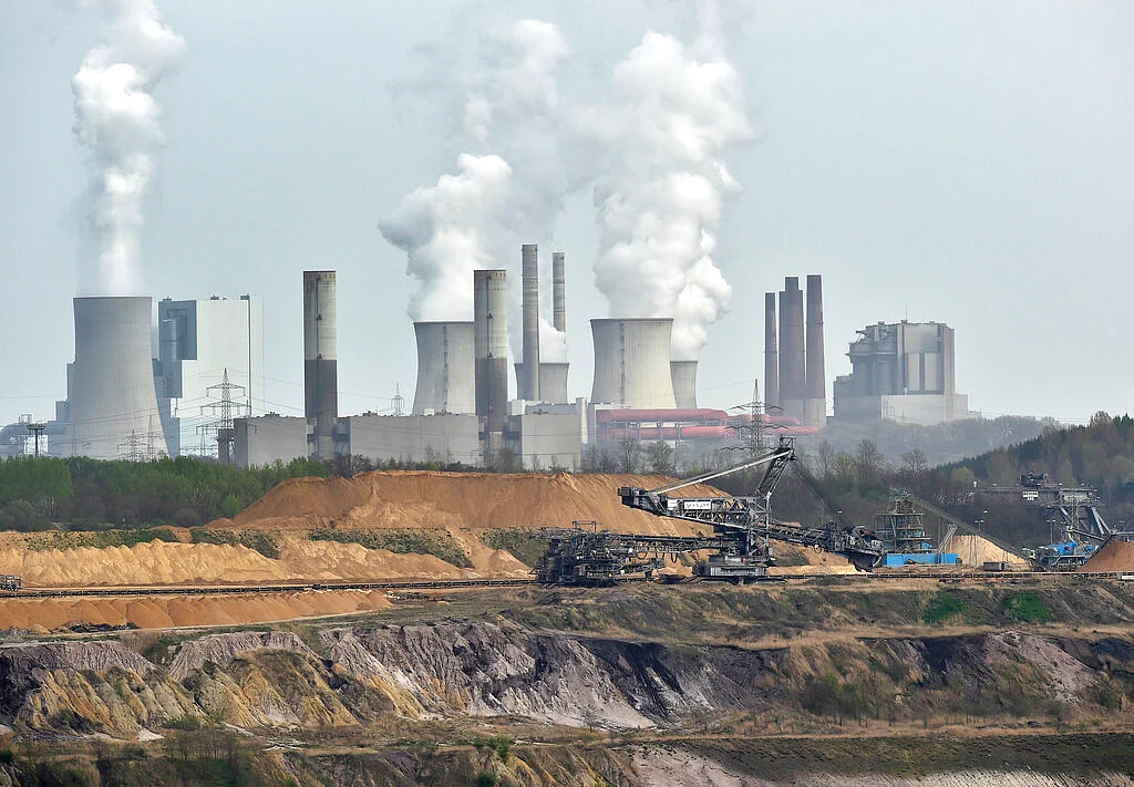 file photo giant machines dig for brown coal at the open-cast mining Garzweiler in front of a smoking power plant near the city of Grevenbroich in western Germany.