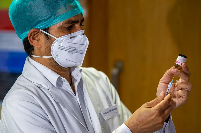 A health worker performs a trial run of COVID-19 vaccine delivery system in New Delhi, India
