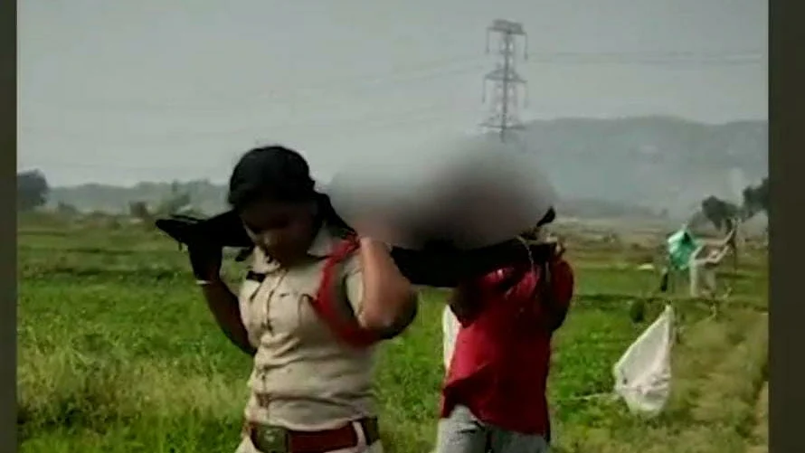 சடலத்தைத் தூக்கிச் செல்லும் காவல் துறை உதவி ஆய்வாளர்.