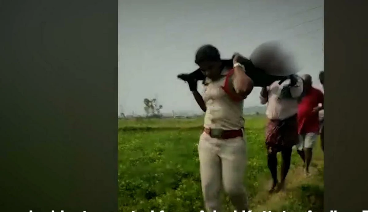 சடலத்தை தூக்கிச் செல்லும் காவல் துறை உதவி ஆய்வாளர்.