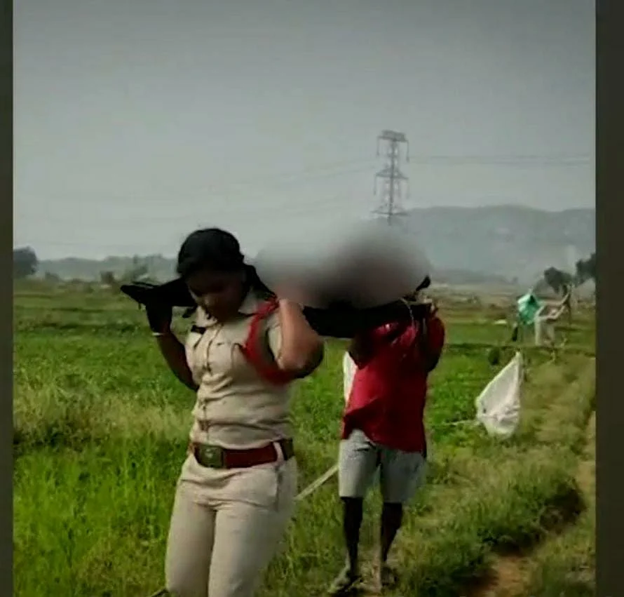 சடலத்தைத் தூக்கிச் செல்லும் காவல் துறை உதவி ஆய்வாளர்.