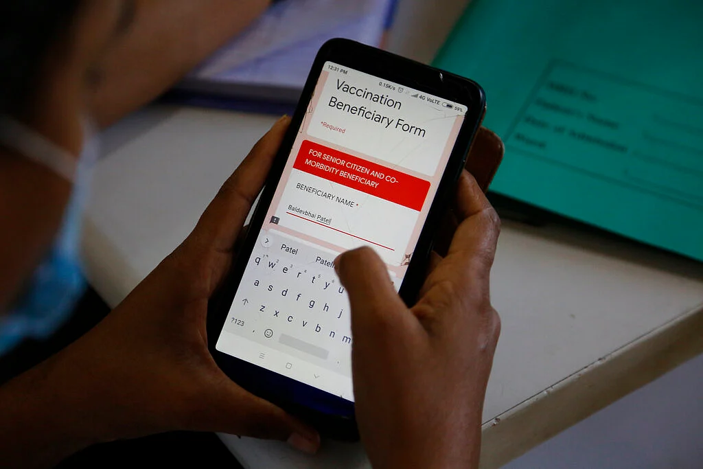 A health worker confirms registration on a mobile application before administering a shot of the Covishield COVID-19 vaccine at Sola Civil hospital in Ahmedabad, India,