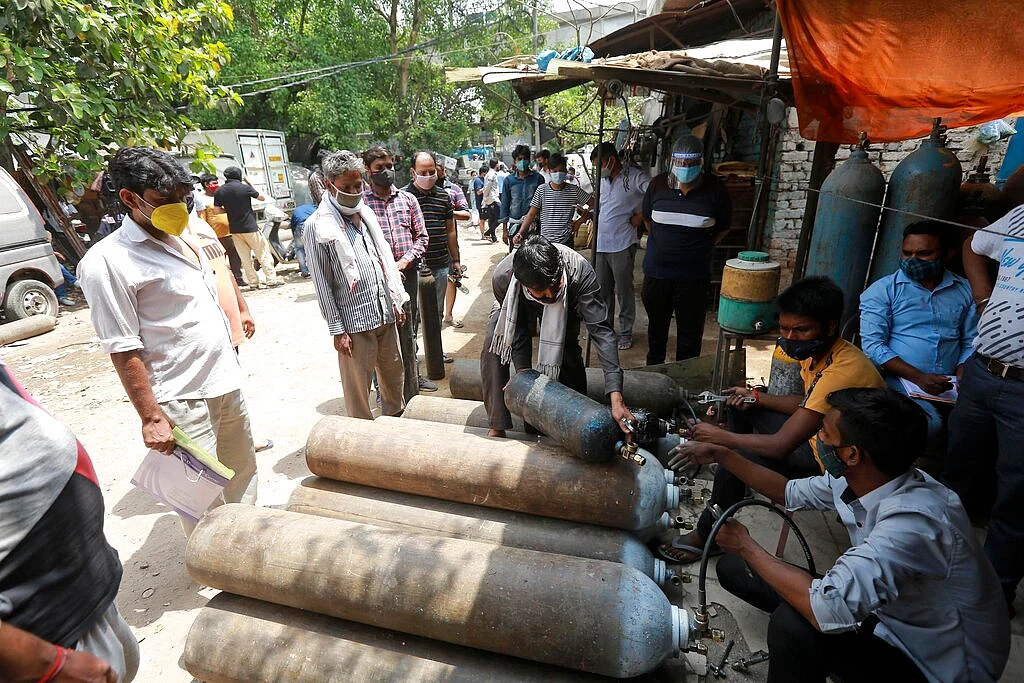 People stand in queues to refill oxygen in cylinders in New Delhi, India