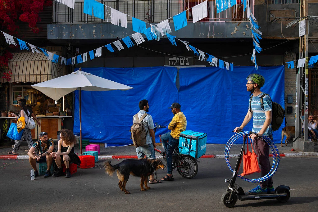 People without face masks hang out in downtown Tel Aviv, Israel, Sunday, April 18, 2021.