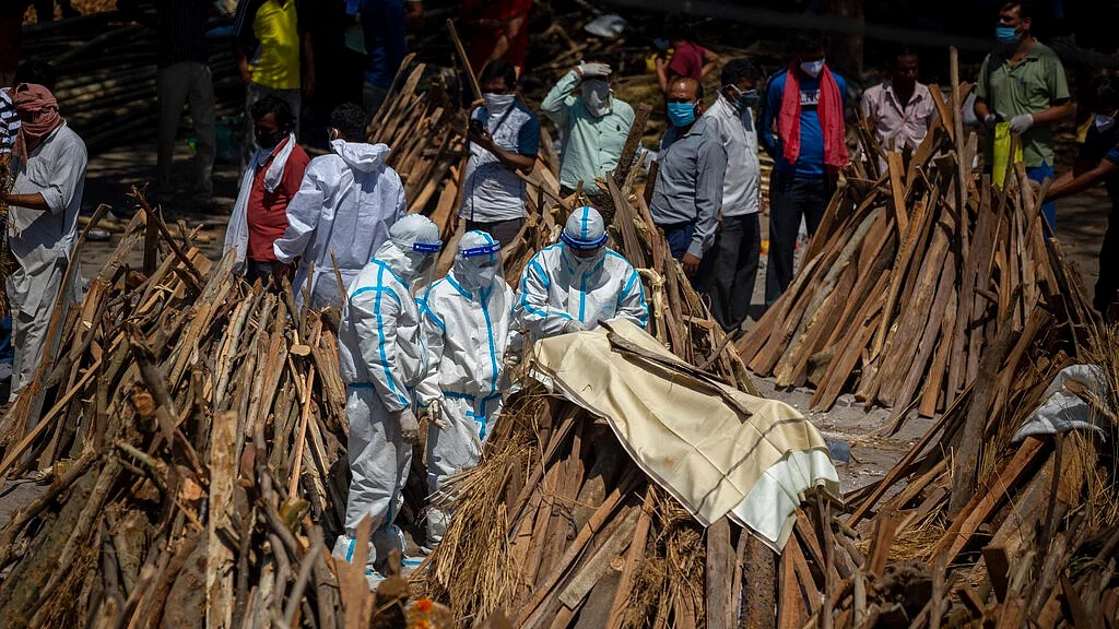 People perform rituals next to a funeral pyre