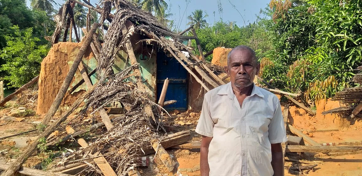 இடிந்து கிடக்கும் வீடு முன்பு சுப்ரமணியன்