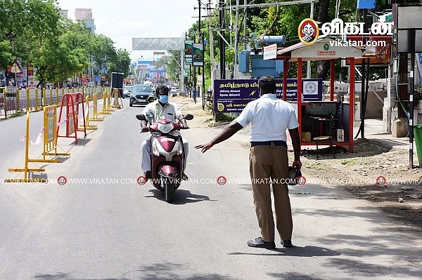 சாலையில் வருபவரிடம் விசாரிக்கும் போலீஸ்