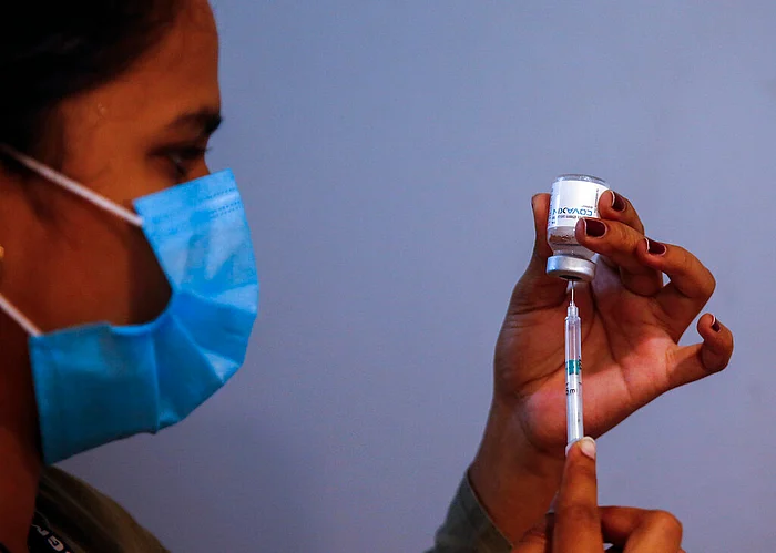 A doctor prepares to administer vaccine