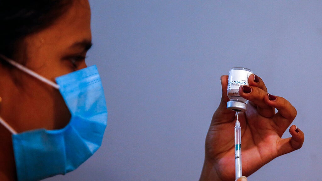 A doctor prepares to administer vaccine