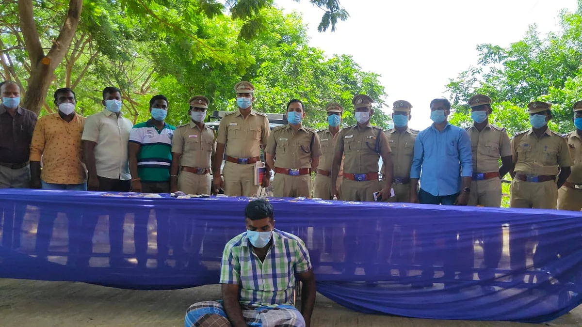 பிடிபட்ட நபருடன் காவல்துறையினர்.