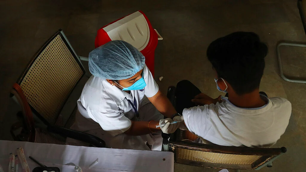 A health worker administers the vaccine