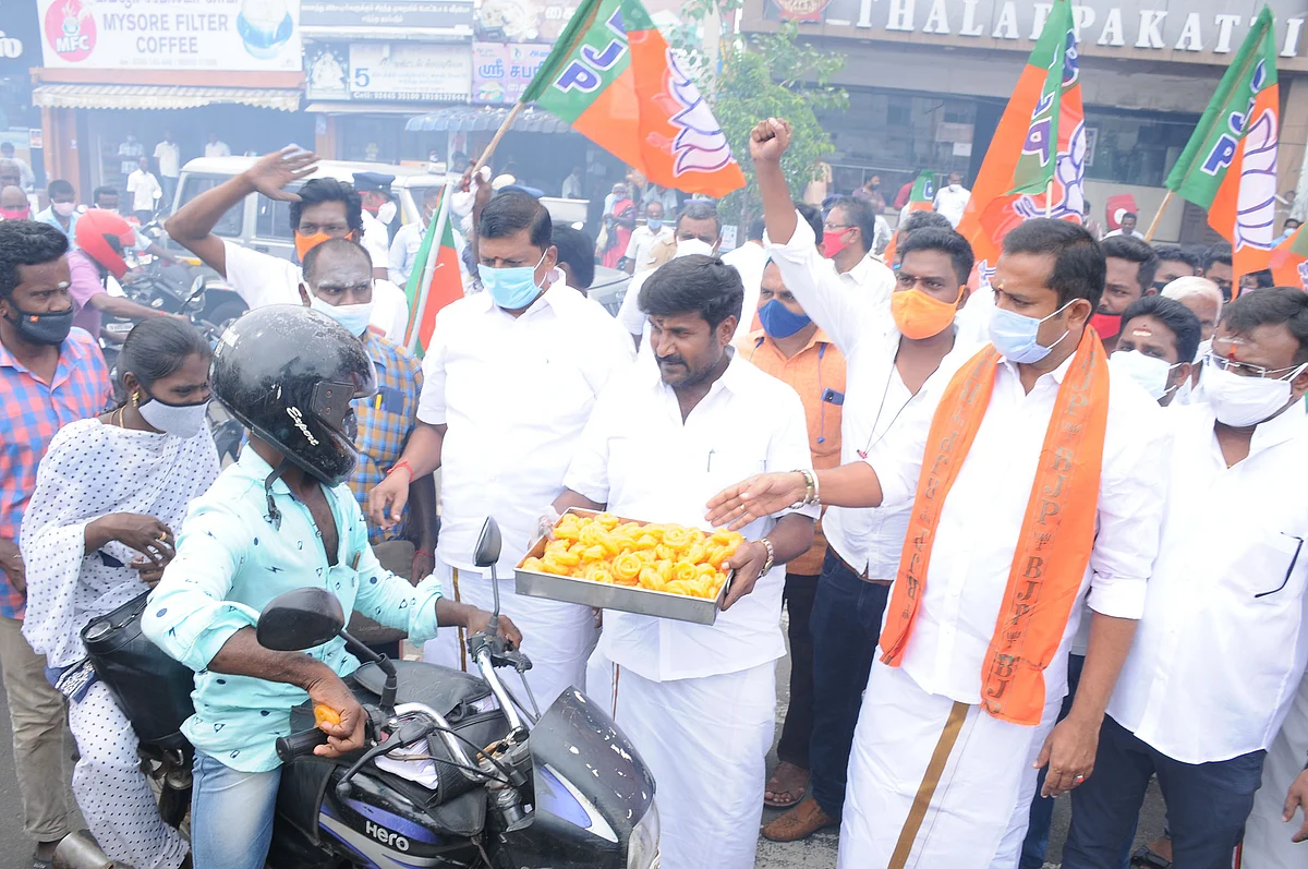 இனிப்பு வழங்கும் பா.ஜ.க-வினர்