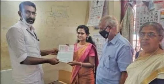 புனலூர் சப் ரெஜிஸ்டர் அலுவலகத்தில் திருமணம் பகிவுசெய்யப்பட்ட சான்றிதழை மணமகள் தன்யா மார்ட்டினிடம் வழங்கும் அதிகாரி