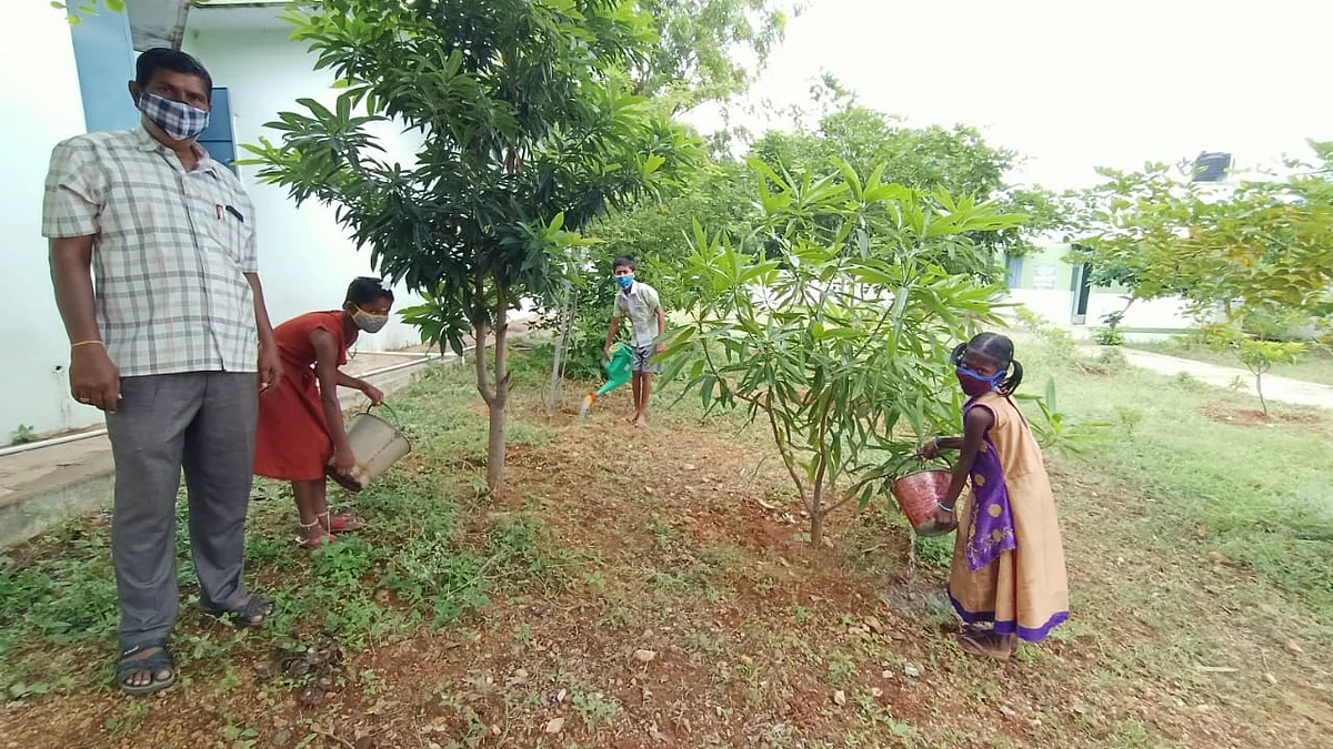 தண்ணீர் பாய்ச்சும் மாணவர்கள்