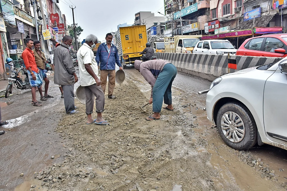 மதுரையில் சாலையில் ஏற்பட்ட பள்ளத்தை மூடும் ஊழியர்கள்